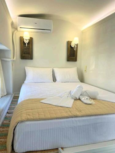 a large bed in a room with two lights on the wall at Calliste Nest In Kasonia, Pothia Harbour in Kalymnos