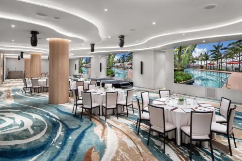a dining room with tables and chairs and a large mural at Crowne Plaza Changi Airport by IHG in Singapore