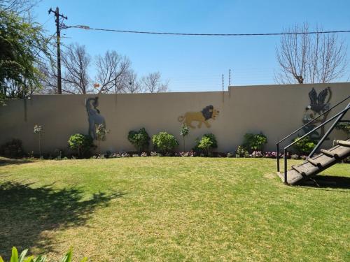a wall with paintings of horses on it at Emerald Guesthouse in Kempton Park