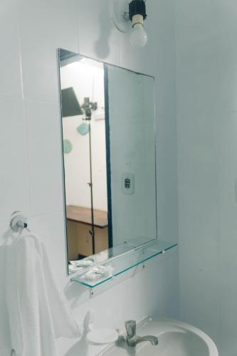 a bathroom with a sink and a mirror at Pousada Canto da Vila in Saquarema