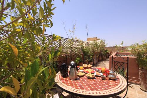 ein Tisch mit Teekessel und Essen auf einer Terrasse in der Unterkunft Riad Zehar & Spa Marrakech in Marrakesch