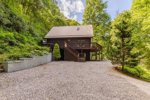 a cabin in the woods with a gravel driveway at Wally`s Kabin in Whittier
