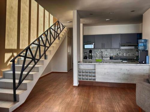 a kitchen with a staircase in a house at Casa de campo con alberca a 10 min del centro del SLP in San Nicolás