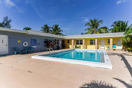 a swimming pool in front of a building at Lovely 1 Bedroom Steps from the Beach in Palm Beach Shores