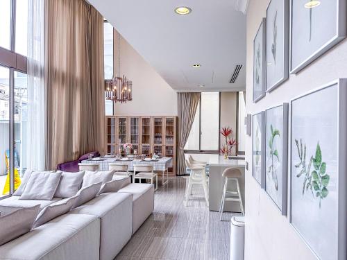 a living room with a couch and a dining room at Sukhumvit-Thonglor Luxury Pool Club Villa 5 Mins to BTS 素坤逸-通羅 豪華會所泳池別墅 5分鐘到達地鐵 in Bangkok
