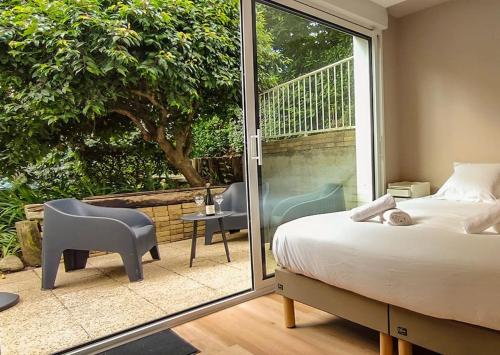 une chambre avec un lit et une porte coulissante en verre dans l'établissement L'Escale - proche du port et des commerces, 4 personnes, à Sainte-Marine