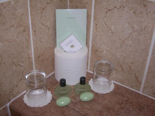 two bottles of detergent and two glasses and a box at Corn Mill Lodge Hotel in Leeds