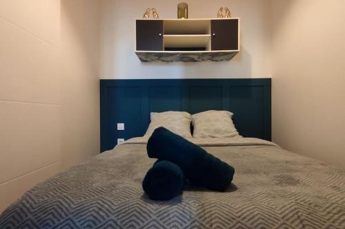 une chambre avec un lit avec une tête de lit bleue dans l'établissement T2 Cosy - Proche place Verdun, à Castelnaudary