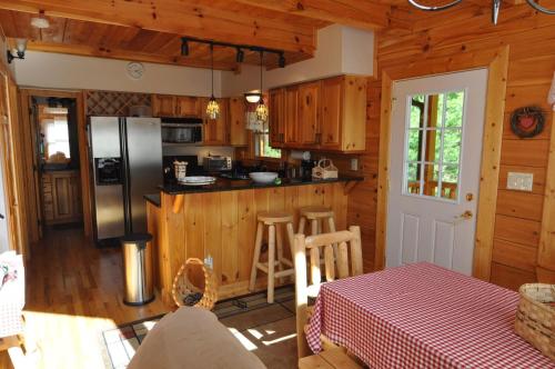 a kitchen with a refrigerator and a table in a cabin at Cherokee Ridge Retreat in Whittier
