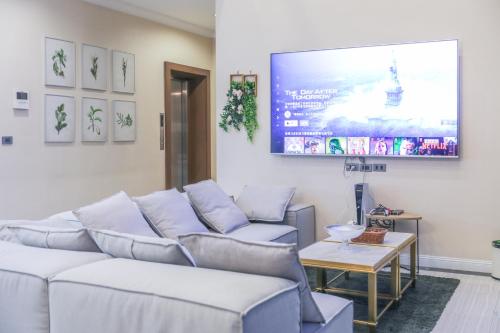a living room with a couch and a flat screen tv at Sukhumvit-Thonglor Luxury Pool Club Villa 5 Mins to BTS 素坤逸-通羅 豪華會所泳池別墅 5分鐘到達地鐵 in Bangkok