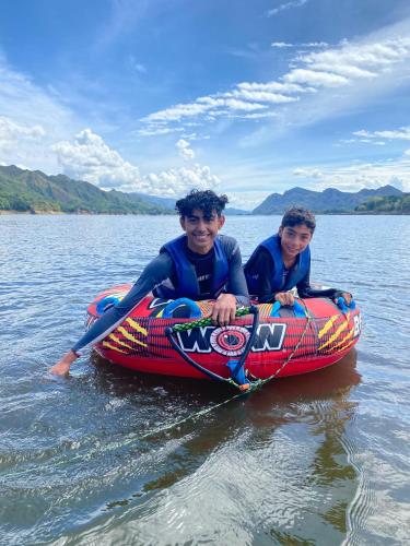 two boys are riding on a raft in the water at Cabaña de Lujo, Isla El Faro in Prado