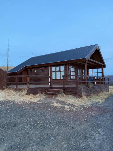 a large wooden cabin with a black roof at Úthlíd Cottages in Úthlid