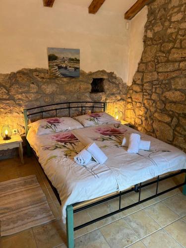 a bedroom with a bed in a stone wall at Villa Jelly in Šmrika
