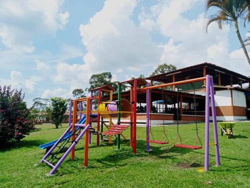 a playground with colorful equipment in a park at FINCA HOTEL LAS CABAÑAS DEL Parque in Pueblo Tapao