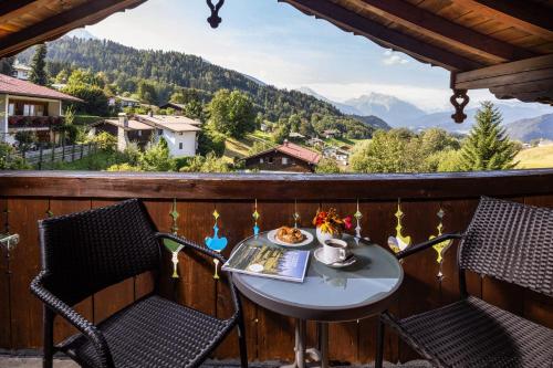 a table and chairs on a balcony with a view at Sportpension Färbinger in Berchtesgaden