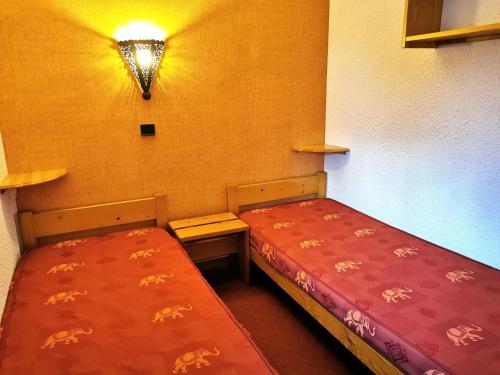 Cette chambre dispose de 2 lits et d'une lumière sur le mur. dans l'établissement Résidence Cristallin - Le Cristallin 41 - Agréable 2 pièces, proche des pistes MAE-4574, à Valmorel
