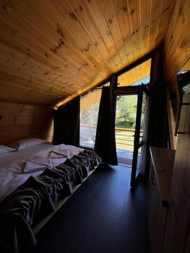 a bed in a room with a large window at Krusta Panoramic Resort in Râșca