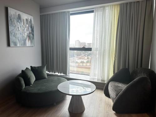 a living room with a couch and a table and a window at ONYX by luna in Oran