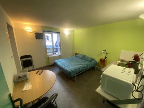 une chambre avec un lit, un bureau et une table dans l'établissement les moulins - studio 6, à Cherbourg en Cotentin