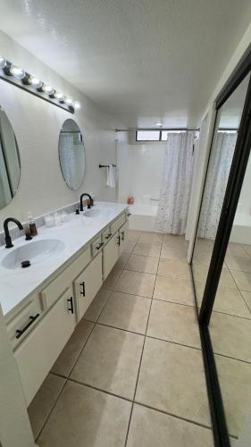 un bagno con due lavandini e un grande specchio di Oasis Hm near Rancho Vista- Shared Hm a Palmdale