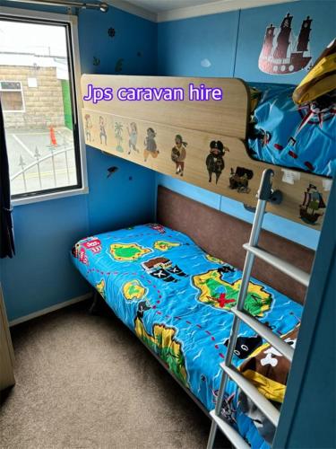 a bedroom with a bunk bed and a ladder at Jps caravans in Kinmel Bay