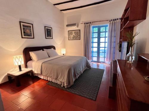 a bedroom with a bed and a large window at Posada Azafran en Choroni in Choroní