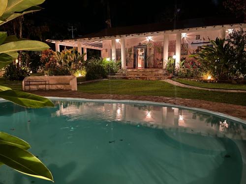a swimming pool in front of a house at night at Posada Azafran en Choroni in Choroní