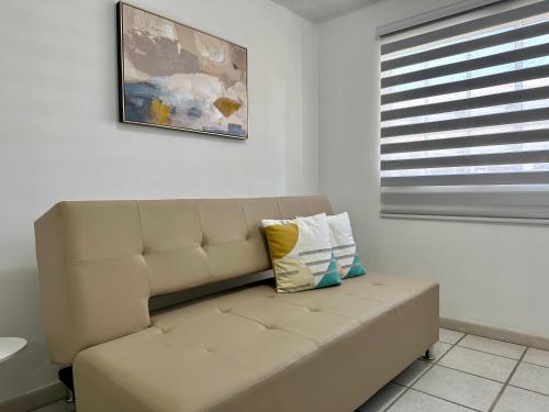 a couch in a living room with a window at Posada Azafran en Choroni in Choroní