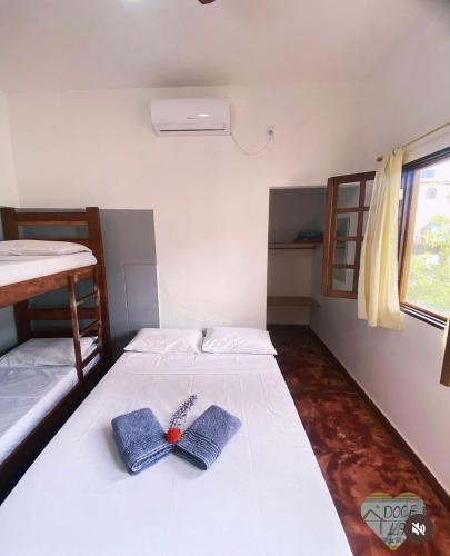 a bedroom with a bed with a pair of shoes on it at Doce Lar Hospedaria in Lençóis