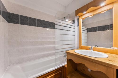 une salle de bain avec un lavabo, une baignoire et un miroir dans l'établissement Résidence Les Hauts De Preclaux - Appartement en rez-de-jardin aux Orres 1800 MAE-3721, aux Orres