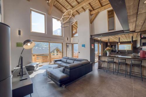 un soggiorno con un divano e un tavolo di Magnifique chalet mitoyen - Jacuzzi - Cousinade II a Les Contamines-Montjoie