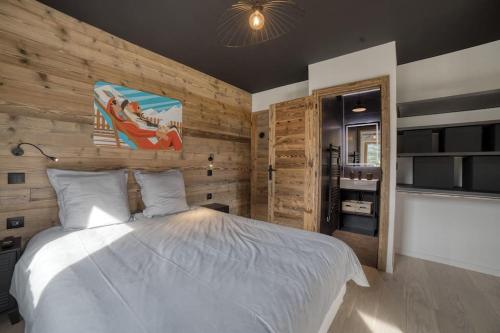 una camera con letto bianco e pareti in legno di Magnifique chalet mitoyen - Jacuzzi - Cousinade II a Les Contamines-Montjoie