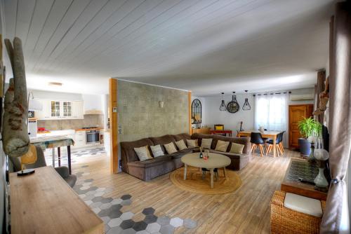 a living room with a couch and a table at Villa Néoulaise 12 couchages in Néoules