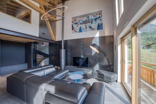 un salon avec un canapé en cuir et une table dans l'établissement Magnifique chalet mitoyen - Jacuzzi - Cousinade II, aux Contamines-Montjoie