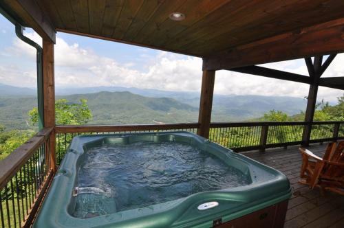 a hot tub on a deck with a view of mountains at A Bear`s Retreat in Bryson City