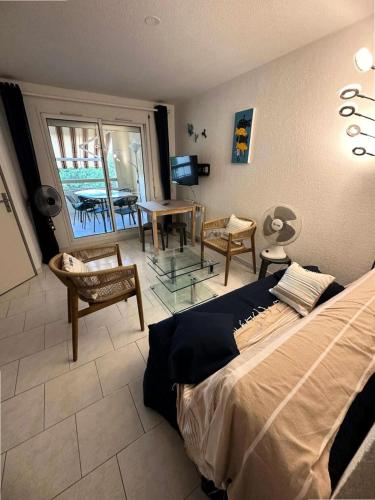 une chambre avec un lit, une table et des chaises dans l'établissement Résidence Lauriers - Appartement T3 dans le Domaine de la Coudoulière a proximité de la mer MAE-7021, à Six-Fours-les-Plages