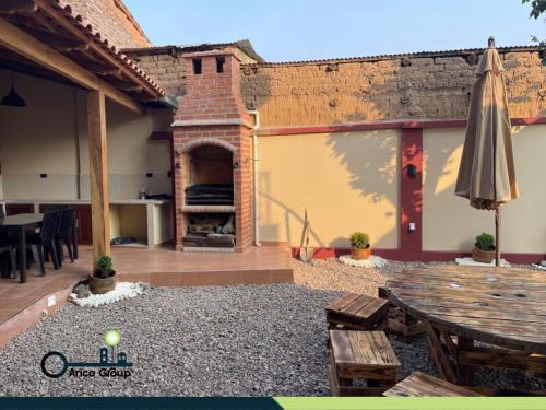an outdoor patio with a table and an umbrella at Chez AriCo, Cochabamba in Calacala