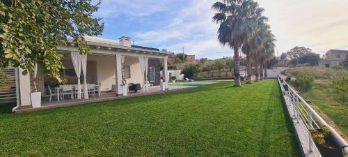 a house with a green lawn in front of it at Villa con piscina in Leonforte