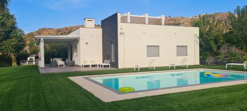 a house with a swimming pool in the yard at Villa con piscina in Leonforte