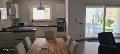 a kitchen with a wooden table and chairs in it at Villa con piscina in Leonforte