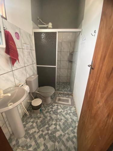 a bathroom with a toilet and a sink and a shower at Doce Lar Hospedaria in Lençóis