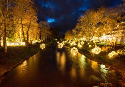 a river with christmas lights in a city at night at Pension Auszeit in Bad Neuenahr-Ahrweiler