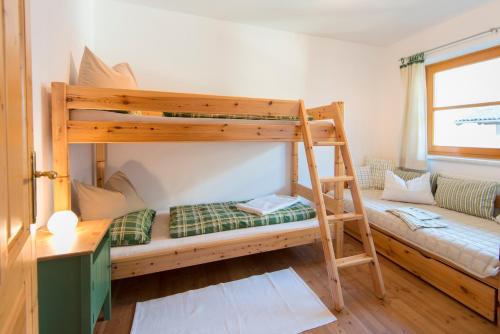 a bedroom with two bunk beds and a couch at Landhaus Resinger in Bad Hofgastein