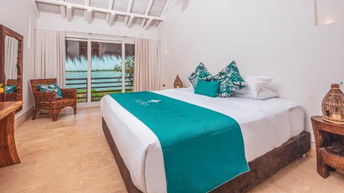 Un dormitorio con una cama grande en una habitación. en Aura Hotel Barú, en Barú