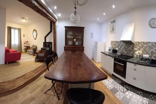 eine Küche und ein Wohnzimmer mit einem Holztisch in der Unterkunft jolie maison de ville in Limoux