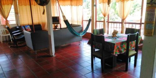 a dining room with a table and chairs and a hammock at alquilo en el queremal valle del cauca colombia in Papagalleros