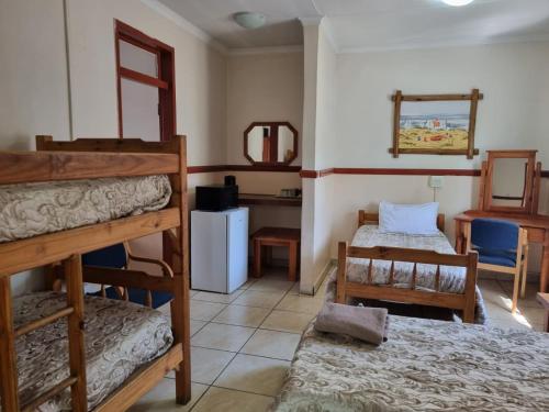 a room with two bunk beds and a mirror at Emerald Guesthouse in Kempton Park