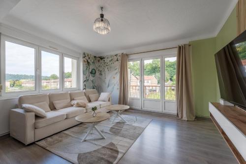 a living room with a couch and some windows at Le Marie 115m - Spacieux 3ch' - 2 sdb - Balcon in Joeuf