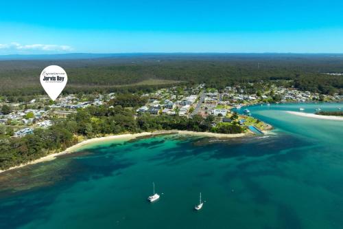 a hot air balloon flying over a beach at Pipis Huskisson by Experience Jervis Bay in Huskisson