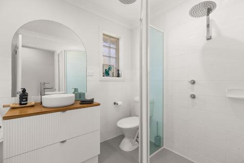 a white bathroom with a sink and a toilet at Pipis Huskisson by Experience Jervis Bay in Huskisson